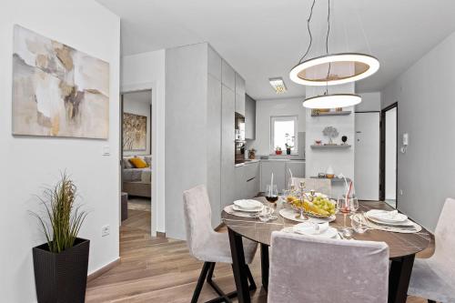a dining room and kitchen with a table and chairs at Apartment Leone Medulin in Medulin