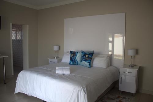 a bedroom with a white bed with a blue pillow at Kanyane @ Graskop in Graskop