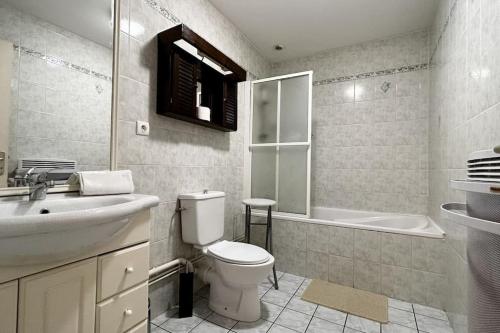 une salle de bain avec toilettes, lavabo et baignoire dans l'établissement Mayocq 1, charmante maison avec jardin, au Crotoy