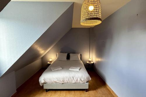 une chambre avec un lit et un lustre dans l'établissement Mayocq 1, charmante maison avec jardin, au Crotoy