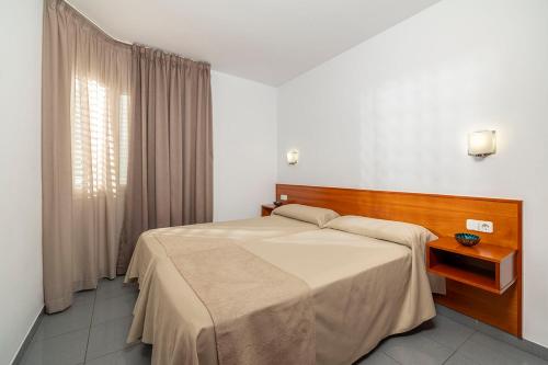 Un dormitorio con una cama grande y una ventana en Apartaments Blau, en Lloret de Mar