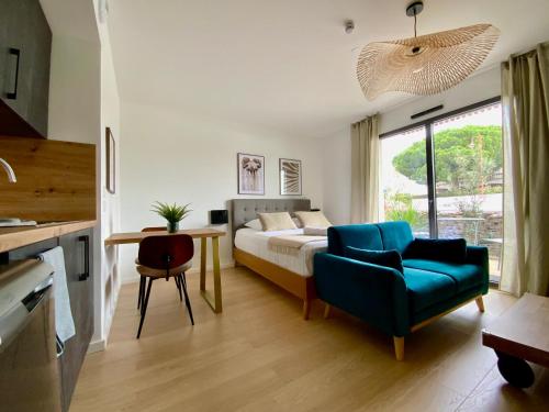 佩羅勒的住宿－Les Loges de la Mer - Pérols，一间卧室配有一张床、一张沙发和一张桌子