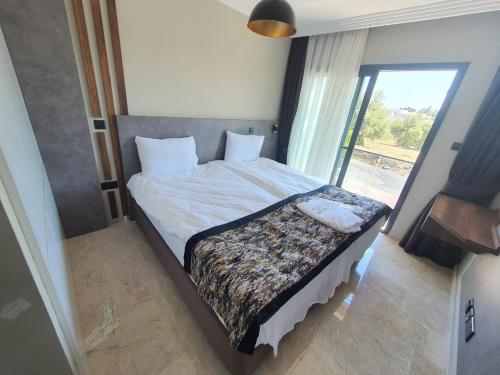 a bedroom with a large bed with a window at Del Mare Park in Kérynia