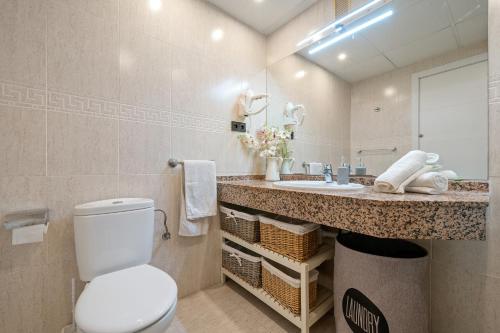 een badkamer met een toilet, een wastafel en een spiegel bij Michelangelo cozy apt in Salou in Salou