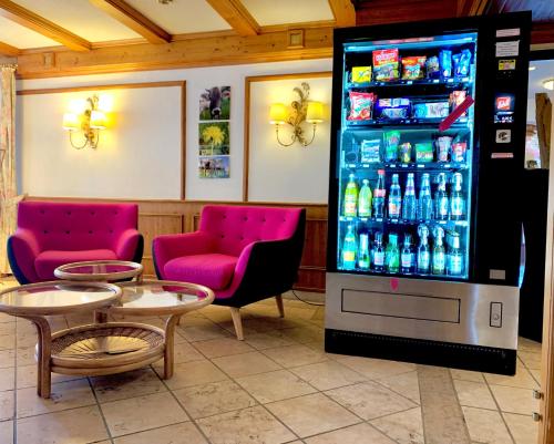 - une machine à soda dans un restaurant avec des tables et des chaises dans l'établissement Alpenrose Appartements, à Nesselwang