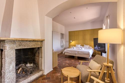 a living room with a fireplace and a bed at Mas Cusi in Palau-Saverdera