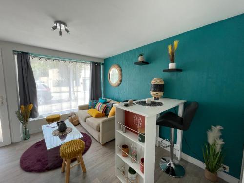 uma sala de estar com uma parede azul em LE GAUGUIN, T2 Cosy, 2-4 Pers, à 300m des plages em Clohars-Carnoët