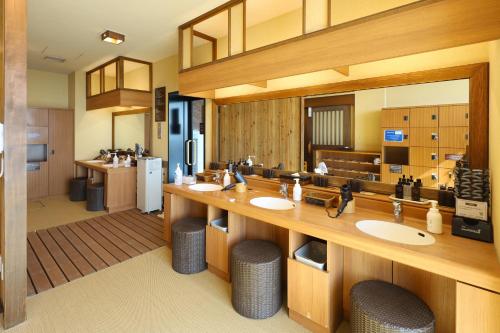 baño con 2 lavabos y espejo grande en Dormy Inn PREMIUM Kushiro, en Kushiro