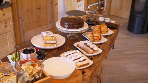 a table filled with different types of pastries and cakes at BB le Fontanelle in Carano