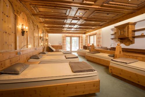 a row of beds in a room with wooden walls at Hotel Silberberger in Oberau