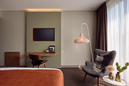 Una televisión o centro de entretenimiento en Van der Valk Hotel Breukelen
