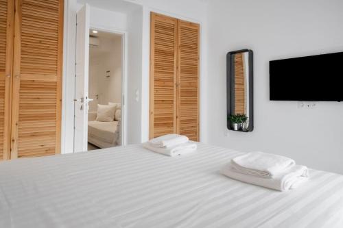 a white bed with two towels on top of it at Luxury Apartment Center of Mykonos Town - Sleeps 3 in Mýkonos City