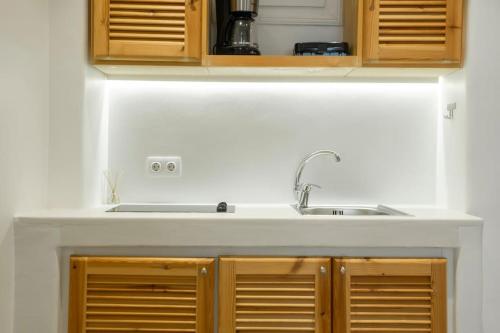 a kitchen counter with a sink and wooden cabinets at Luxury Apartment Center of Mykonos Town - Sleeps 3 in Mýkonos City