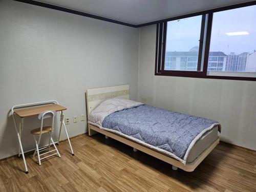 een slaapkamer met een bed, een bureau en een raam bij Dongtan Sharp-2 Family House 