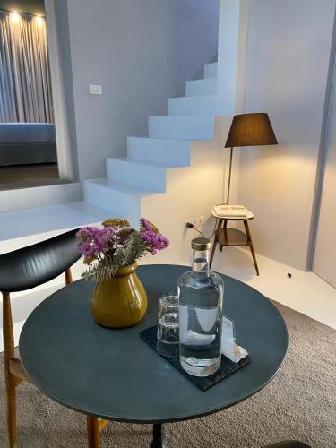 a table with a glass bottle and flowers on it at Riva Lofts Florence in Florence