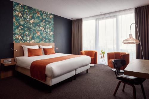 ブリューケレンにあるヴァン デル ヴァルク ホテル ブルーケレンのベッドとデスクが備わるホテルルームです。