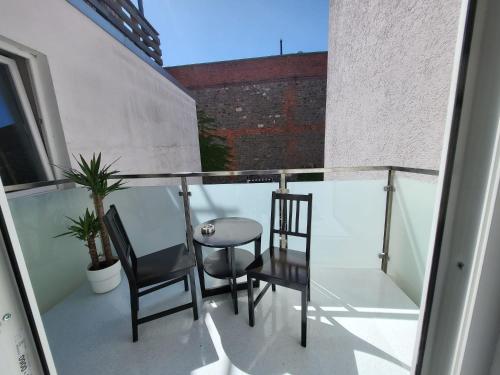 balkon z 2 krzesłami i szklanym stołem w obiekcie Exquisite, gemütliche kleine Wohnung mit Balkon w mieście Wolmirstedt