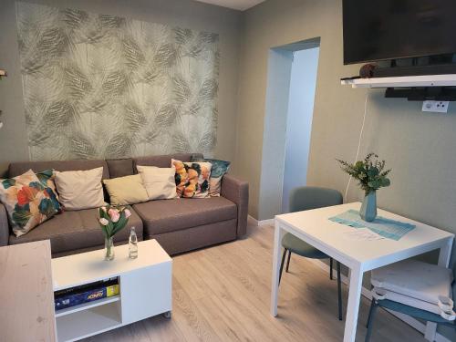 uma sala de estar com um sofá e uma mesa em Exquisite, gemütliche kleine Wohnung mit Balkon em Wolmirstedt