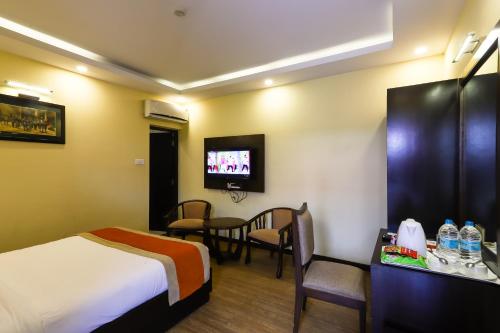 um quarto de hotel com uma cama e uma televisão em Dreamland Gold Resort & Hotel em Bhairahawa
