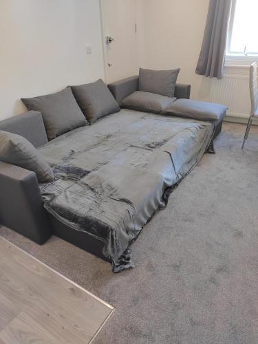 a large bed in a living room with a couch at Top Quality Modern Southsea Garden Apartment Sleeps 4 People in Portsmouth