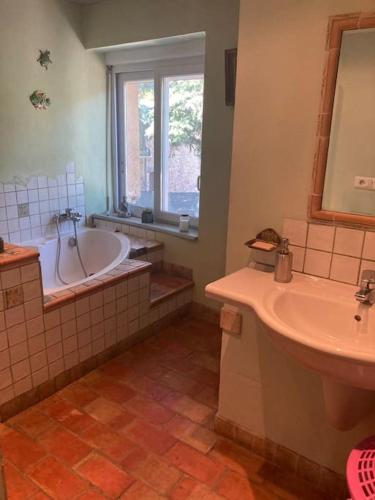 a bathroom with a tub and a sink and a bath tub at Maison a Rustrel (A coté du Colorado Provençal ) in Rustrel