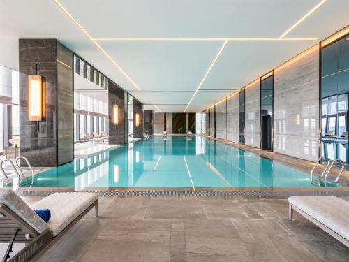 a large swimming pool in a building at Pullman Jiaxing Pinghu Excellence in Jiaxing