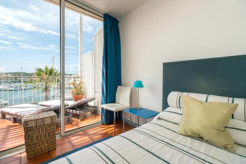 a bedroom with a bed and a large window at Marina de Lagos Penthouse - 250m from beach in Lagos