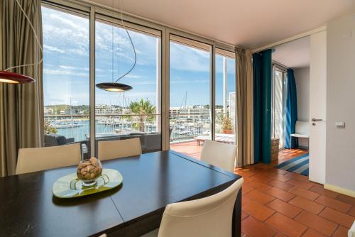 a dining room with a table and a large window at Marina de Lagos Penthouse - 250m from beach in Lagos