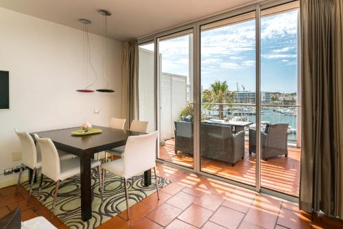 a dining room with a table and chairs and a balcony at Marina de Lagos Penthouse - 250m from beach in Lagos