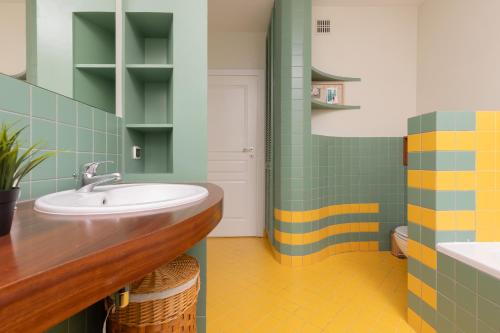 een badkamer met een wastafel en groene en gele tegels bij Spacious & Quiet 1 Bedroom Apartment in Pruszków by Renters in Pruszków