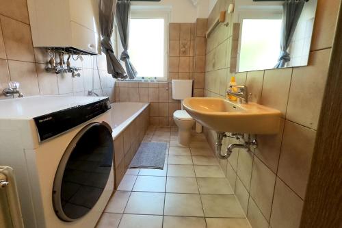 a bathroom with a sink and a washing machine at Work & Stay Apartment with Balcony in Osnabrück