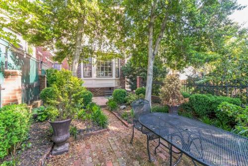 a patio with a table and chairs in a garden at Historic Petersburg Row Home in Petersburg