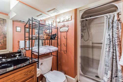 a bathroom with a shower and a toilet and a sink at Historic Petersburg Row Home in Petersburg