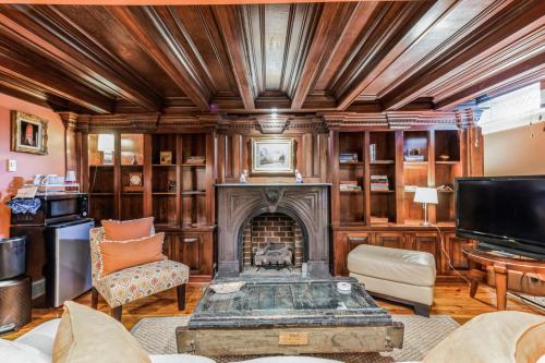 a living room with a fireplace and a tv at Historic Petersburg Row Home in Petersburg