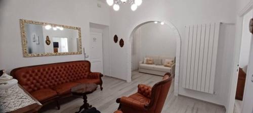 a living room with a couch and a mirror at Cozy Home Away from Home in Tarquinia