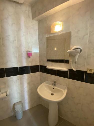 ein Badezimmer mit einem weißen Waschbecken und einem Spiegel in der Unterkunft AY OTEL 2 in Antalya