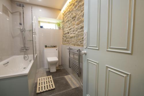 uma casa de banho com um WC, um lavatório e uma porta em 3 Mill Cottages em Ravensworth