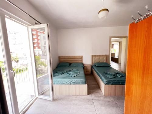 a bedroom with two beds and a balcony at Vila Manuel in Shëngjin