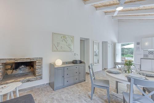 a living room with a fireplace and a table and chairs at Eco House Casa Grigia Zabodarski Beach - Happy Rentals in Cunski