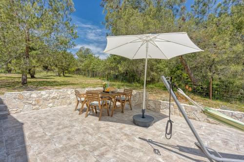 een patio met een tafel en een parasol bij Eco House Casa Grigia - Happy Rentals in Čunski