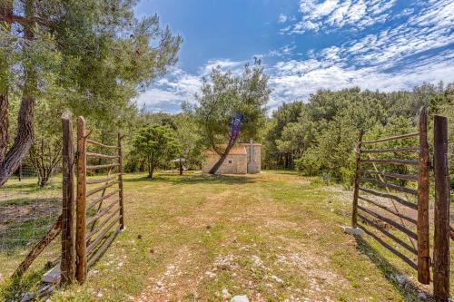 a wooden fence in a field with trees at Eco House Casa Grigia - Happy Rentals in Cunski