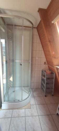 a glass shower in a room with a attic at Domki MEDYK in Jantar