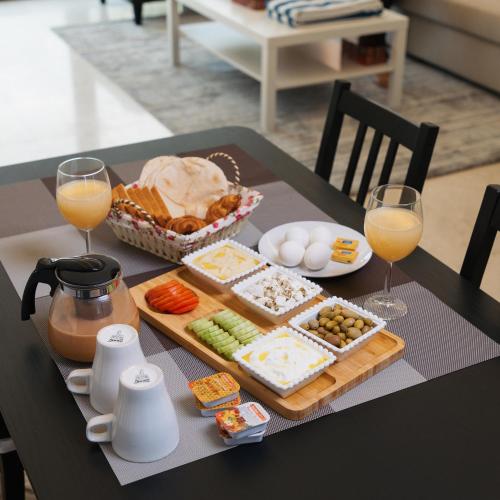 a table with a tray of food and glasses of orange juice at THE POOL VILLA - TANUF in Nizwa