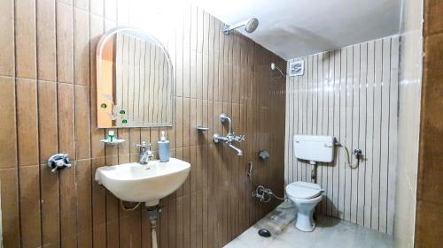 a bathroom with a sink and a toilet at Hotel Rajyashree Palace in Varanasi
