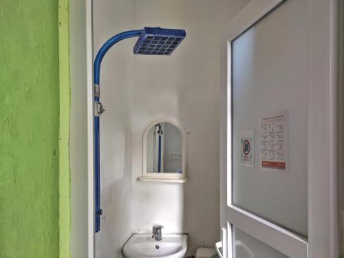 a small bathroom with a sink and a mirror at Hostel Ureki Kidobani in Ureki