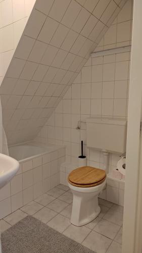 een witte badkamer met een toilet en een wastafel bij B&B Dorp en Duin in Egmond aan Zee