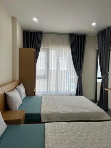a bedroom with a bed and a large window at Thao Nguyen Homestay in Quy Nhon