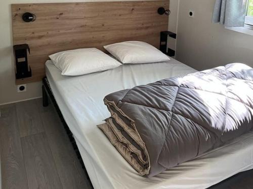 a bed with white sheets and pillows in a bedroom at Camping les Cigales Rocamadour in Rocamadour