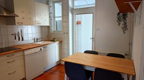a kitchen with a wooden table and chairs at Appartementen Dorp & Duin in Egmond aan Zee