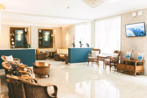 a hotel lobby with chairs and tables and a waiting room at Dostyk Kokshetau in Kokshetau